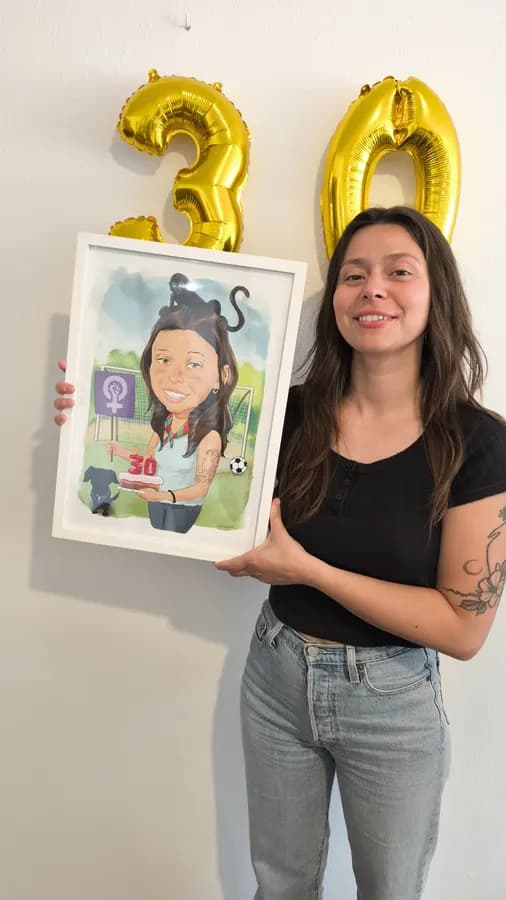 Una clienta amb la seva caricatura emmarcada, en una festa de 30 anys