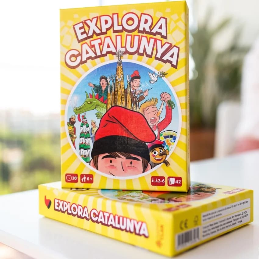 Capsa del joc de cartes «Explora Catalunya» (Happy Clan), amb la Sagrada Família, un drac i uns castellers il·lustrats per l’estudi