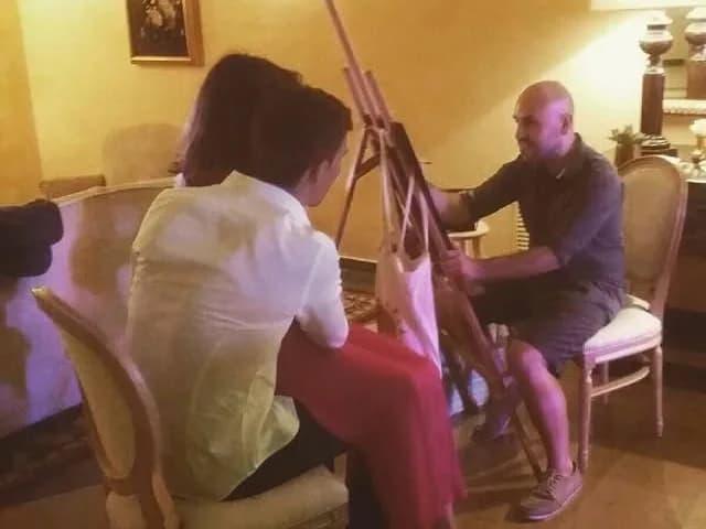 En Xevi dibuixant caricatures en directe al cavallet, davant de dues convidades, en un esdeveniment